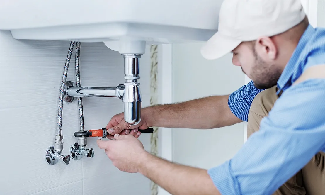 fontanero profesional apretando tuberias de lavabo